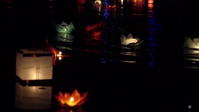 Festival of lanterns on the water. Water lantern in the shape of a Lotus with a candle flame floating at night on the water.