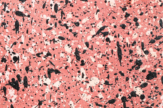 pink concrete wall with black and white spots  texture