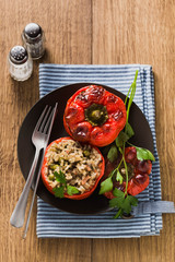 Ready baked stuffed peppers in a plate on a wooden table. healthy vegan cuisine for the whole family. comfort food