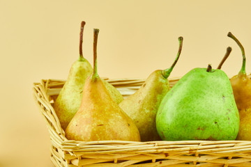 Tasty and fresh pears in wooden basket
