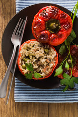 Ready baked stuffed peppers in a plate on a wooden table. healthy vegan cuisine for the whole family. comfort food