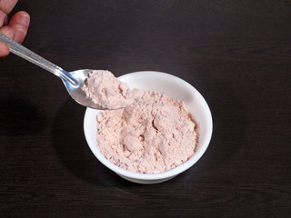 Black Salt in White Bowl on Hand, Black Salt on Wooden Background, Black Salt Called Kala Namak in...