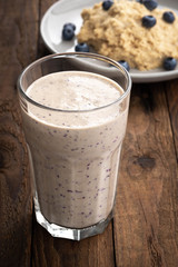 macro chocolate blueberry smoothie in a glass on a rustic table