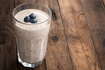 macro chocolate blueberry smoothie in a glass on a rustic table