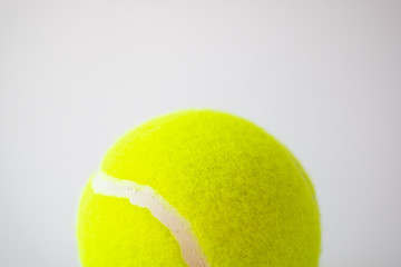 part of new yellow tennis ball on white background, copy space on top
