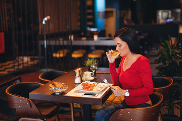 Young woman on breakfast in a restaurant