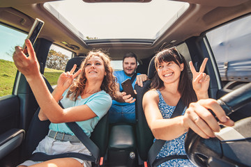 road trip group of people making selfie in the car