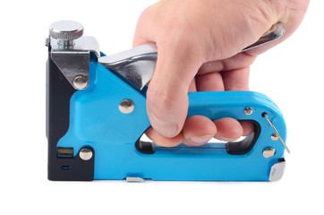 The furniture stapler in a man's hand isolated