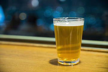 Beer in classic glass with bokeh background