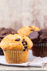 Homemade muffins with chocolate, vintage background.