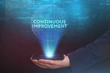 The concept of business, technology, the Internet and the network. A young entrepreneur working on a virtual screen of the future and sees the inscription: Continuous improvement