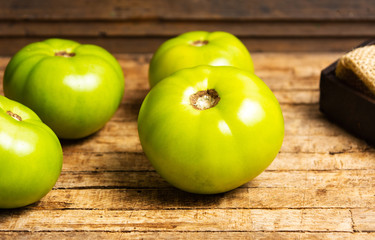 Green tomato on a rustic wooden table