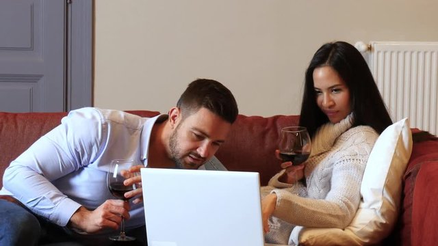 A beautiful young couple in the living room discussing content on a smartphone.
