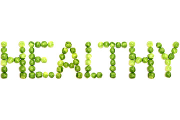 Brussel sprouts spelling the word healthy on a plain white background