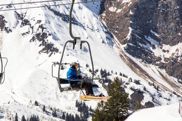 Fototapeta na wymiar Snowboarder hanging around on a ski or chair lift in the French Alps resort of Avoriaz in the Portes du Soleil ski region