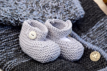 Fototapeta na wymiar Strickjacke und Babyschuhe aus Wolle, Handarbeit