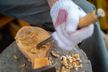 Craftsman demonstrates the process of making wooden spoons handmade using tools. National crafts...