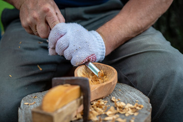 Craftsman demonstrates the process of making wooden spoons handmade using tools. National crafts...