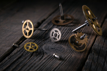 Obraz premium Clockwork gears of time bronze on wooden table. Concept time and ideas support