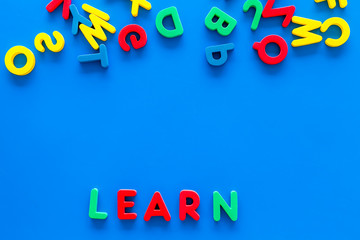 Children learn read concept. Word learn written by plastic letters on blue background top view copy space
