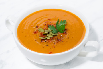 soup of pumpkin and lentils on white background, closeup