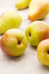 Fresh pears with leaves in a on wooden background.