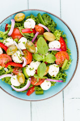 Vegetable salad with cheese mozzarella, tomatoes, basilikum and spice.
