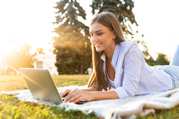 Happy young girl spending time at the park, studying