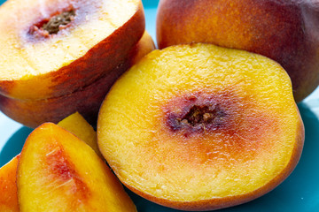 Peaches all cut up and ready for breakfast on a blue plate sitting on the kitchen table