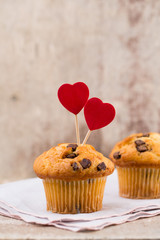 Homemade chocolate muffins with heart, vintage background.