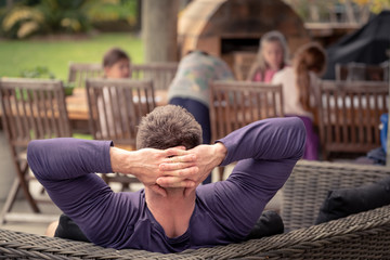 dad relaxing while girls draw at garden table