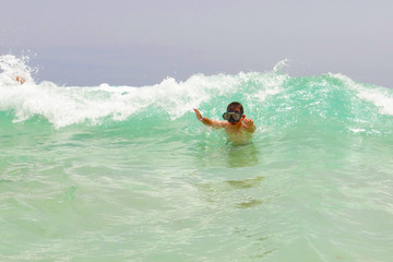 Jugentlicher Surfer wartet auf den richtigen Moment, Welle