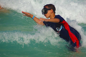 Jugentlicher Surfer springt auf die Welle