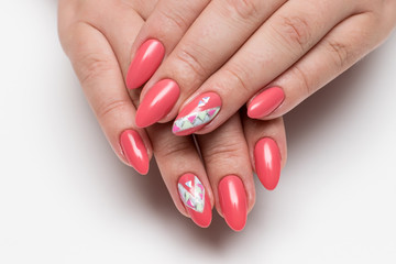 Coral, pink, orange manicure with crystals and a rhombus painted on long sharp nails on a white background close-up 