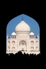 Taj Mahal in India. Popular tourist destination. Arch view with tourists in front.
