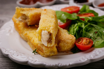 Fish sticks fried in breadcrumbs on a plate