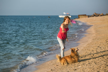girl playing with a dog on the beach