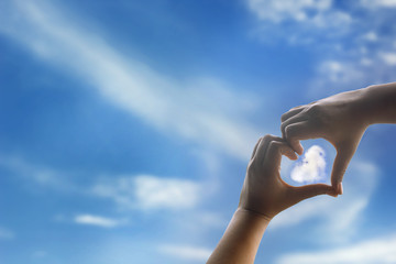 Heart shaped hand, cloud and sky