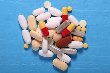 pills and capsule on blue background