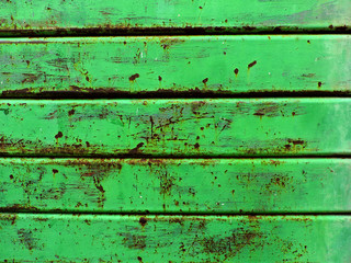 Background of green painted steel with rust