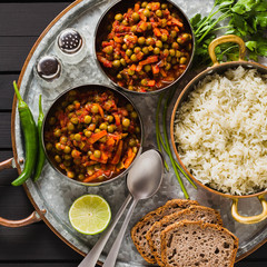 vegan curry with green peas and basmati rice served on a wooden table tray, healthy Indian comfort food