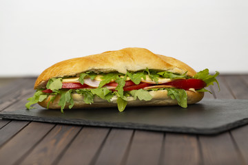 Baguette sandwich with ham, tomatoes, cheese and arugula lettuce. Delicious Breakfast or snack....
