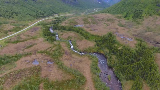 Aerial view of mountain road and river in cloudy day in Norway