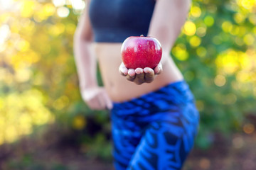 Close-up of a woman body. Woman holding an apple. Dieting concept.