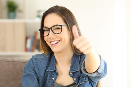 Happy girl with thumbs up in a house interior