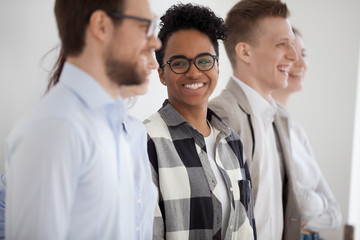 Smiling laughing leader African woman standing with company staff professionals together talking have a fun. Diverse group business people employees in office, friendly and successful team concept