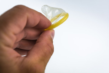 Close-up of a condom in his hand. Contraceptive protection against pregnancy, AIDS.