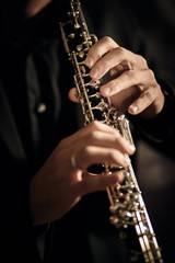 Oboe player on dark background musician - obrazy, fototapety, plakaty