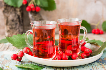 Hot tea from hawthorn berries in transparent glasses on a wooden table