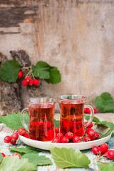 Hot tea from hawthorn berries in transparent glasses on a wooden table